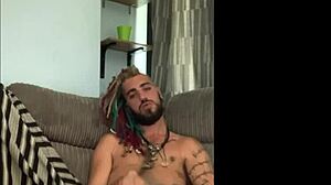 dreddy the emo punk dude with tattoos and alternative hairstyle strokes his cock solo in a casual scene
