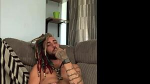 dreddy the emo punk dude with tattoos and alternative hairstyle strokes his cock solo in a casual scene