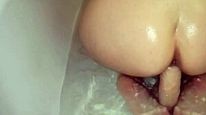 Amateur girl with juicy big ass masturbates solo in shower, using toys for fingering and squirting orgasm close-up