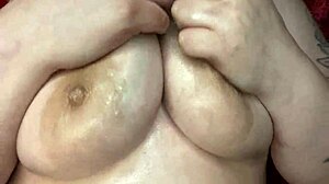 Sexy bbw woman massages her big natural tits with oil.