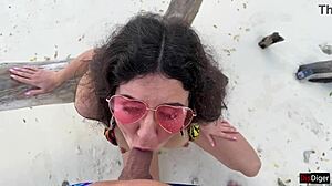 A beautiful teen receives a golden shower on her face at the public beach.