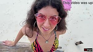 A beautiful teen receives a golden shower on her face at the public beach.