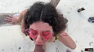 A beautiful teen receives a golden shower on her face at the public beach.
