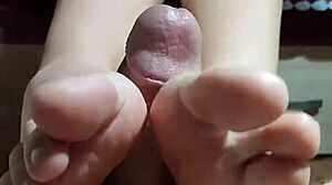 Asian girl satisfies cock with her legs and hands