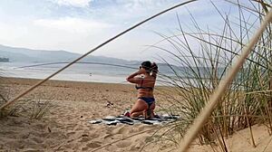 Curvy brunette MILF strips naked and works out on the beach