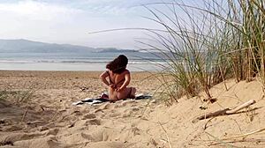 Curvy brunette MILF strips naked and works out on the beach