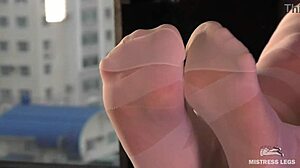 Goddess in white pantyhose wiggling her nylon feet and toes on a table