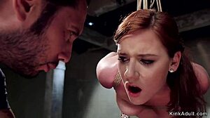 Tied up redhead undergoes training session