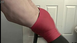 bodybuilder grinds on stool in black tights and red shorts while flashing underwear