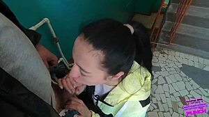 Brunette girlfriend gives huge cock a risky blowjob and swallow on public staircase
